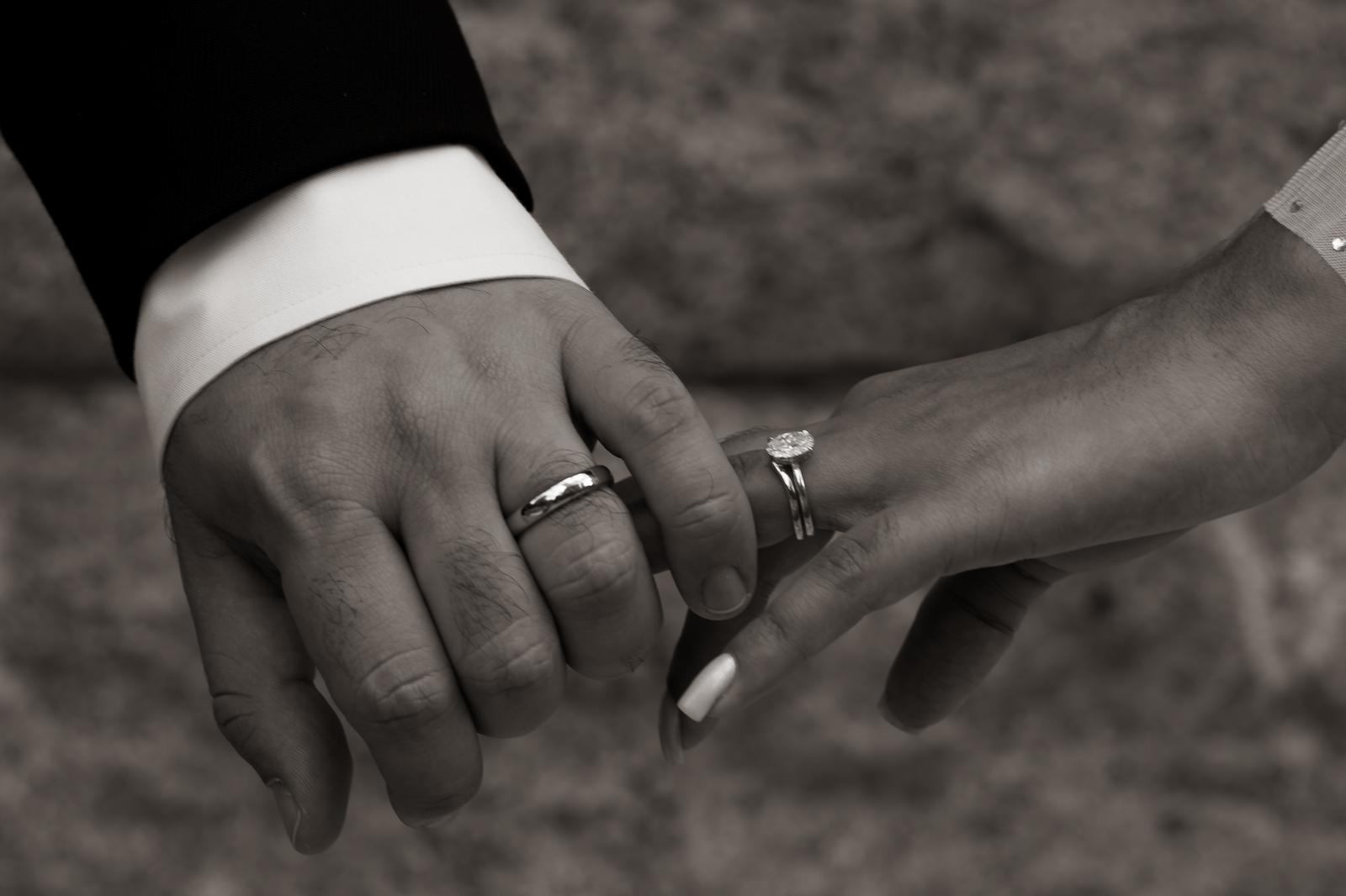 Las manos de Diego y Valentina con sus anillos en blanco y negro